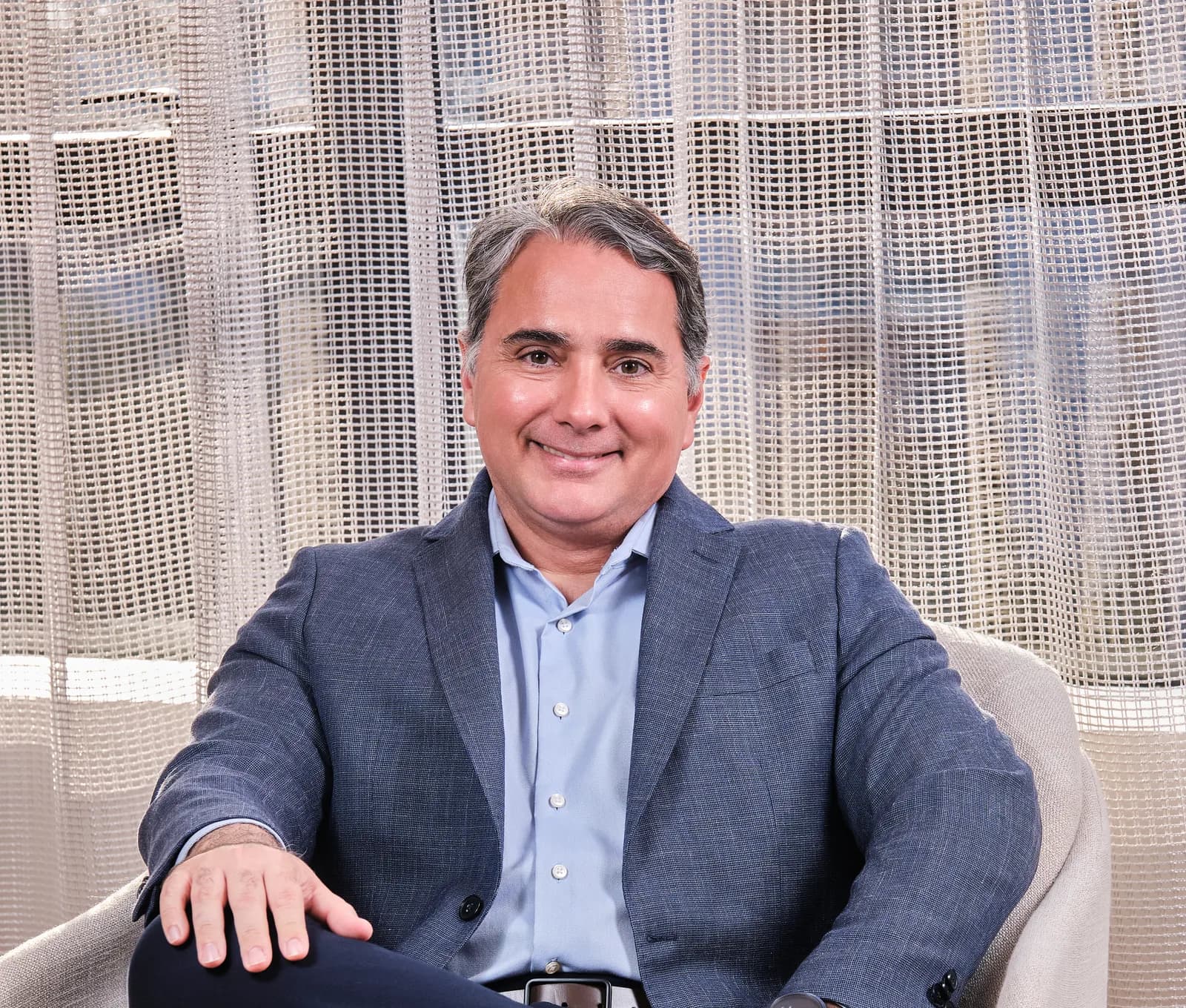 Dr. João Marcelo Lyra sorrindo, sentado numa poltrona da Logos Vision