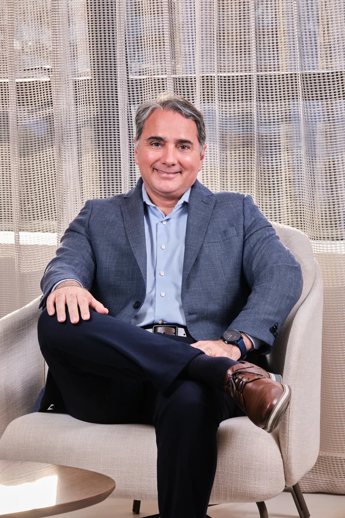 Dr. João Marcelo Lyra sorrindo, sentado numa poltrona da Logos Vision