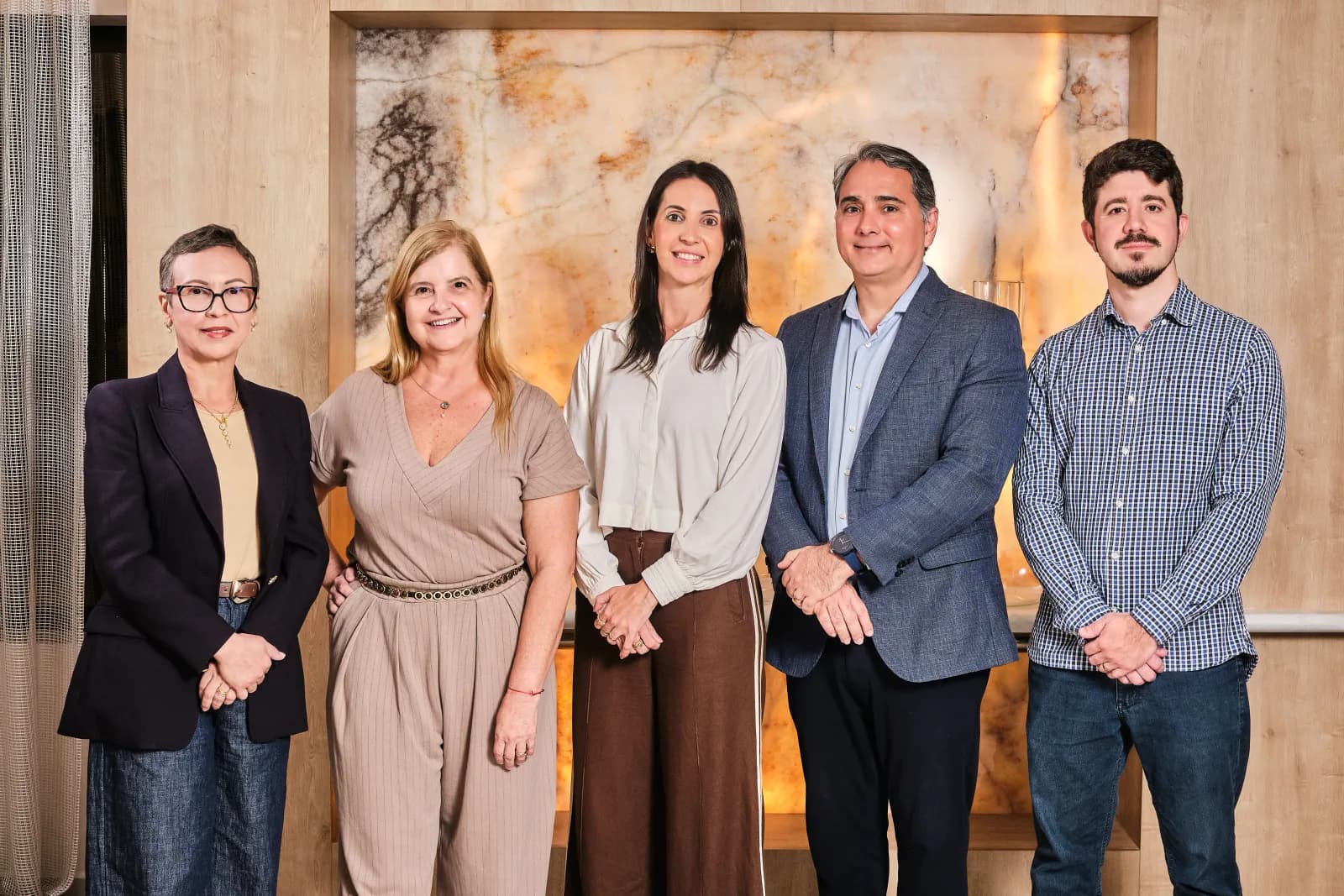 Cinco profissionais da equipe Logos Vision lado a lado no hall da clínica